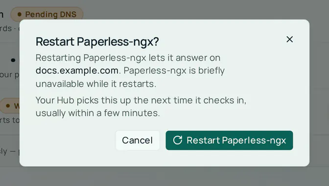 The Restart Paperless-ngx? dialog. It says restarting Paperless-ngx lets it answer on docs.example.com, that the app is briefly unavailable while it restarts, and that the Hub picks this up the next time it checks in. The buttons are Cancel and Restart Paperless-ngx.